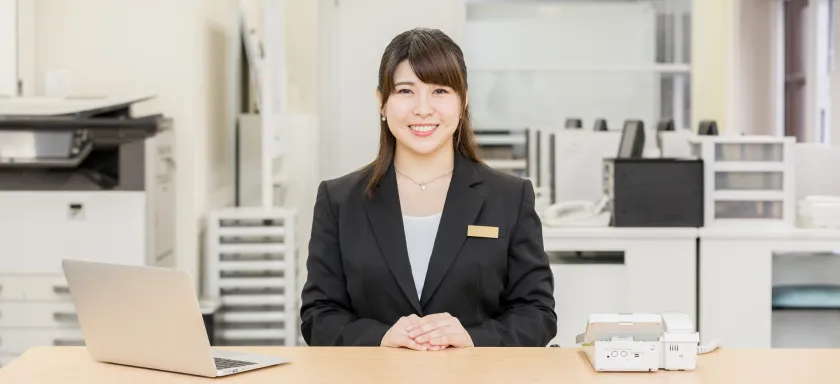 笑顔でお客さまをお迎えする受付の女性